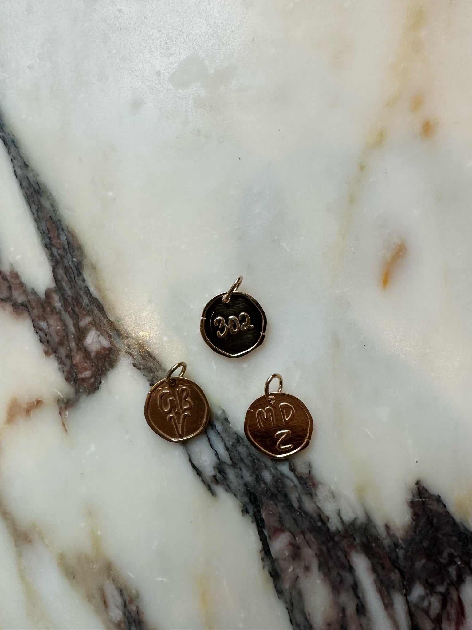 Kaja Erika Jorgensen 18k yellow gold Coin Charms with personalized numbers and letters.